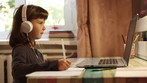 Ein Schulmädchen lernt online mit einem Laptop, während es zu Hause in Quarantäne sitzt.