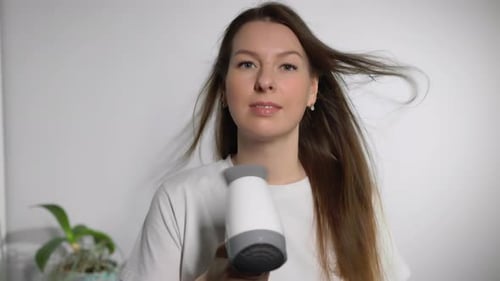 Woman Dries Her Hair with a Hair Dryer