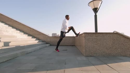 Young Adult Stretches Leg in Urban Setting