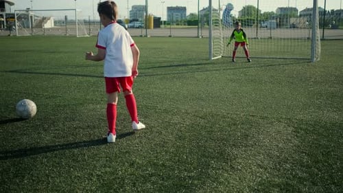 Der junge Fußballspieler schießt ein Tor