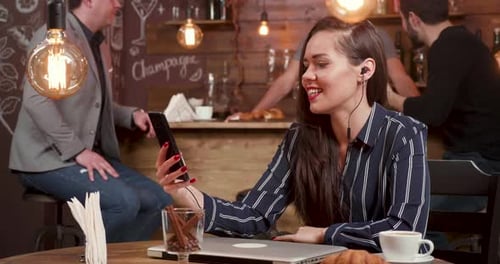 Beautiful Female Freelancer Having a Video Chat in a Coffee Shop