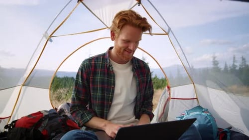 Ruivo usando laptop durante a caminhada