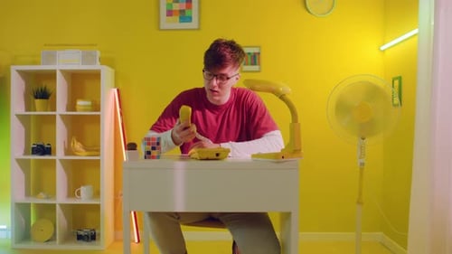 Young Adult Talking on Retro Telephone in Yellow Room