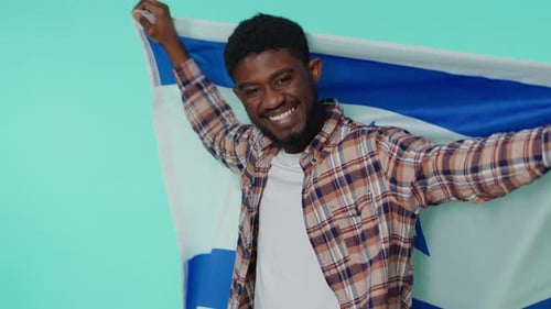 Smiling Man Posing with a Flag Indoors