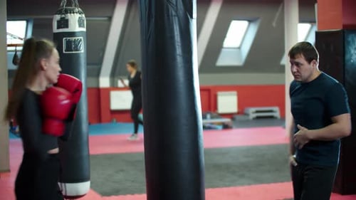 Female Boxer Training with Coach in Gym