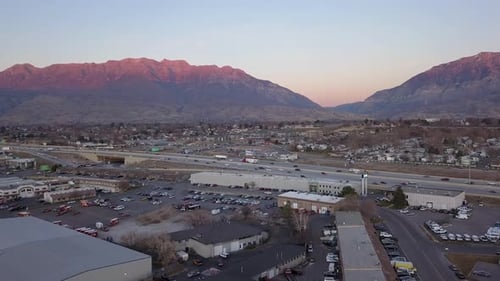 Aerial View Flying Over Industrial Buildings Towards Freeway Traffic
