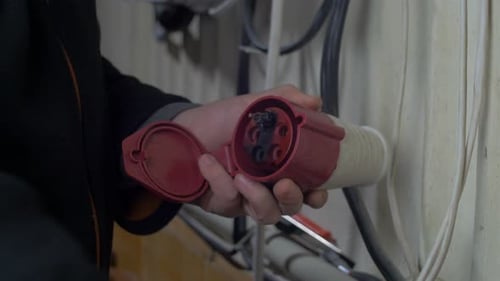 Electrician Repairing Red and White Electrical Plug
