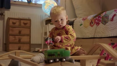 Baby Playing with Trains in Bedroom
