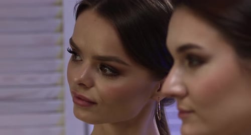 Applying Eye Makeup with Brush on Young Woman