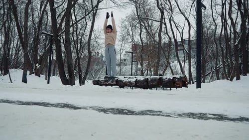 Homme faisant un exercice de burpee sur la neige dans un parc