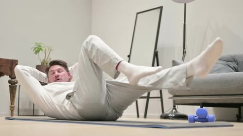 Mann mittleren Alters trainiert zu Hause auf einer Yogamatte