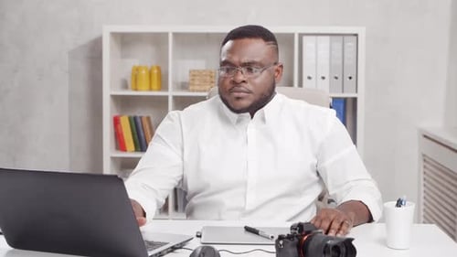 Workplace of freelance worker at home office. Young African-American man.
