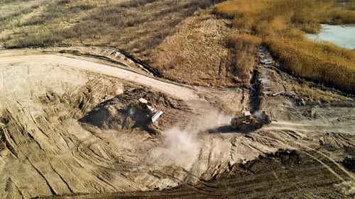 Eine große Baustelle mit Bulldozerschmutz und Staub - Luftaufnahme