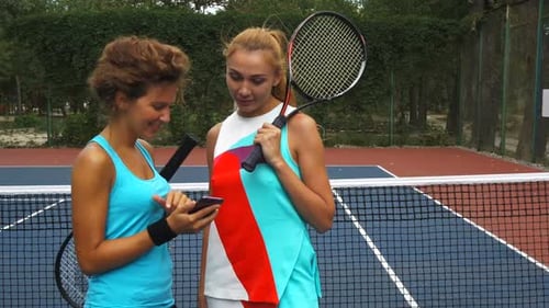 Women Enjoy Tennis and Look at Phone
