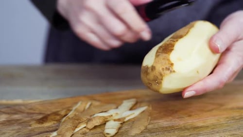 Gelbe Bio-Kartoffeln mit Kartoffelschäler schälen