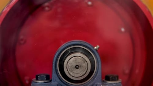 Side view of moving round shaped trommel of red color