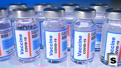COVID-19 vaccine vials on blue surface