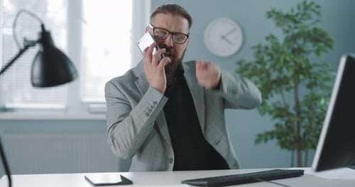 Man Angrily Talking on Phone in Office