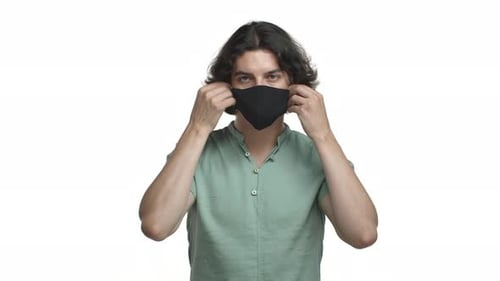 Young Adult Putting on a Protective Face Mask