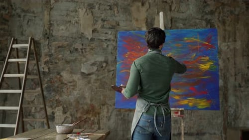 Painter working on canvas in studio