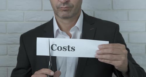 Businessman Cutting Costs with Scissors in Office Environment