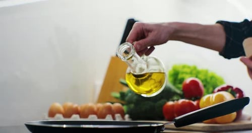 Woman Pours Oil on a Frying Pan on an Electric Stove