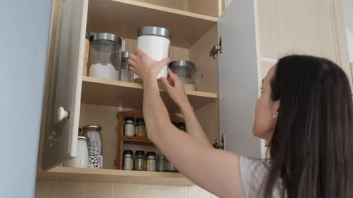 The Housewife Opens a Drawer of the Cupboard in Which Cereals are Stored