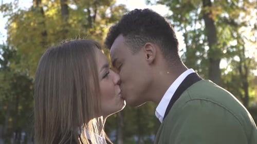 Affectionate Couple Kissing in Autumn Sunlight
