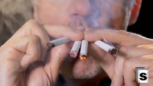Adult Lights Four Cigarettes at Once in Studio