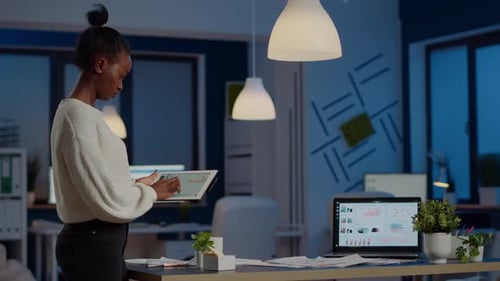 Black Woman Employee Standing in Office and Analysing Charts