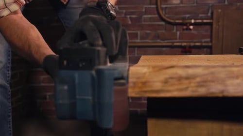 Close Up Shot of the Worker Who Holds a Grinding Machine for Woodwork