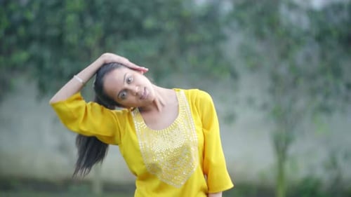 Indian woman doing neck stretch exercise and Yoga in a park