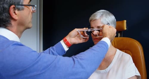 Mature Woman Getting Fitted for Eyeglasses by Doctor