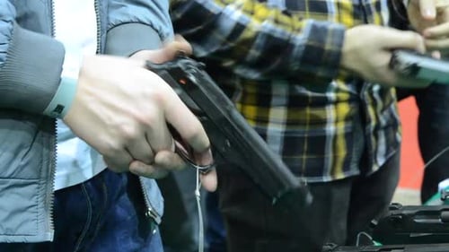 Person Holding a Gun in Hand