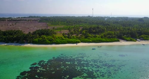Wide fly over travel shot of a white sand paradise beach and aqua blue ocean background in colorful