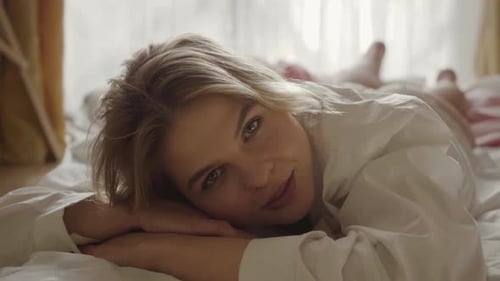 Visage rapproché d'une jeune femme charmante allongée sur le lit le matin. Fille caucasienne souriante