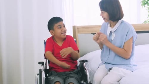 Boy in Wheelchair Talks with Dark Haired Woman