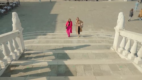 Stylish Women Walk Down Stone Steps in City