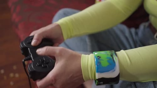 Hands Holding a Black Gaming Controller