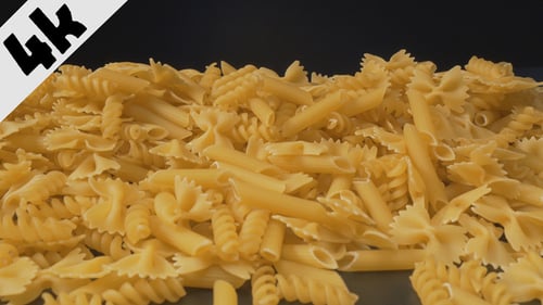 Uncooked Pasta Noodles Scattered Against Black Background