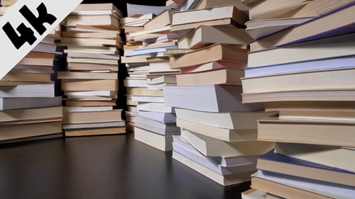 Stacks of Books Piled High on a Dark Surface