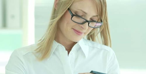 Smiling Woman Using Cellphone in the Office