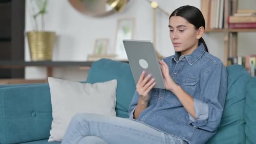 Young Woman Relaxing at Home Using Tablet