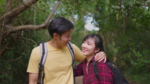Portrait of Young Asian man and woman couple travel in the forest together for honeymoon.