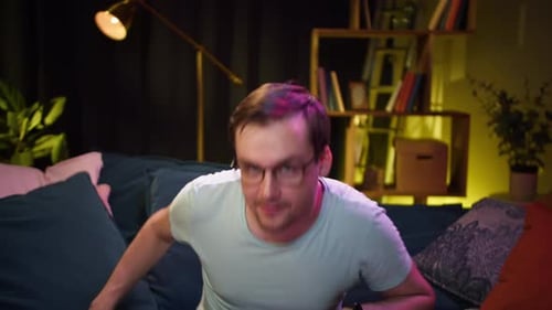 Man Playing Video Game on Couch at Night