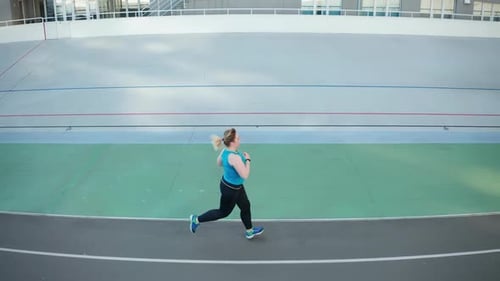 Drone View of Overweight Woman Running Along Track
