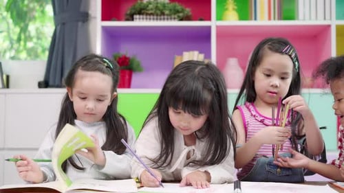 Kids Drawing Together at Table Indoors