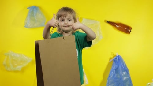 Niña activista con celofán y paquetes de papel. Reduzca la contaminación por plástico. Proteja el medio ambiente