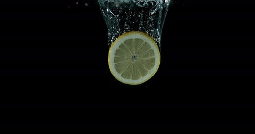 Lemon Slice Splashing Into Water Bubbles on Black