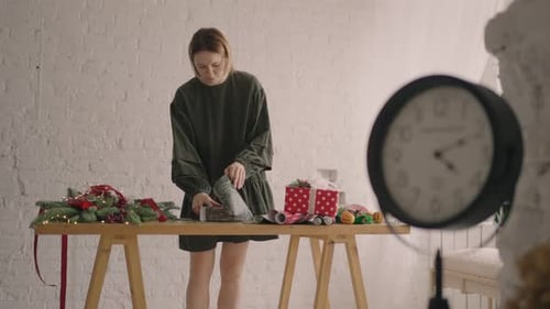 Woman Wrapping Christmas Gift at Table